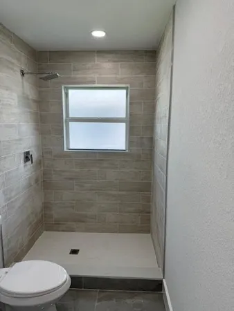 a bathroom with a toilet and a shower