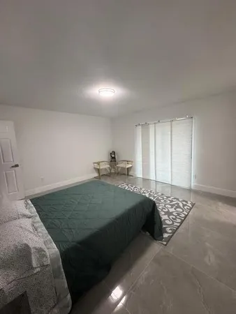 a kitchen with stainless steel appliances kitchen island granite countertop a table chairs sink refrigerator and microwave