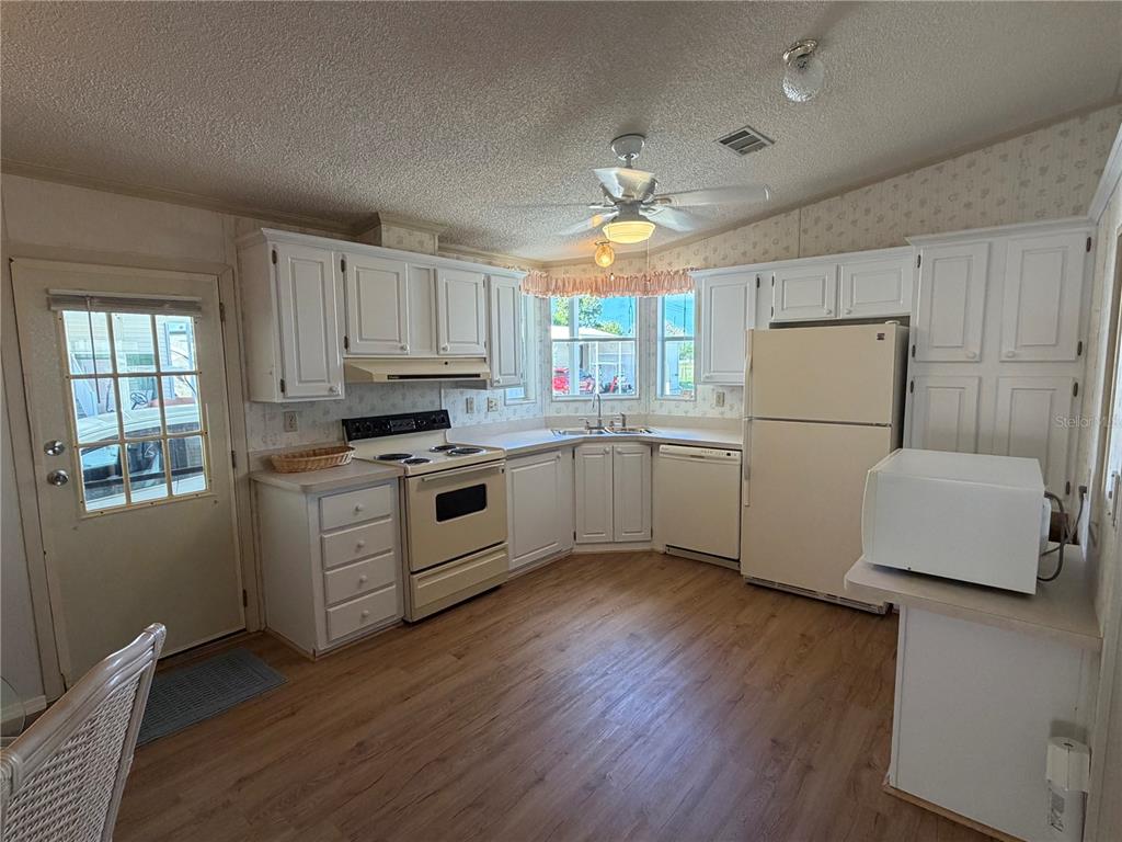 208 Eagle Punta Gorda, FL 33950 - Photo 4 of 16 a kitchen with cabinets wooden floor and stainless steel appliances