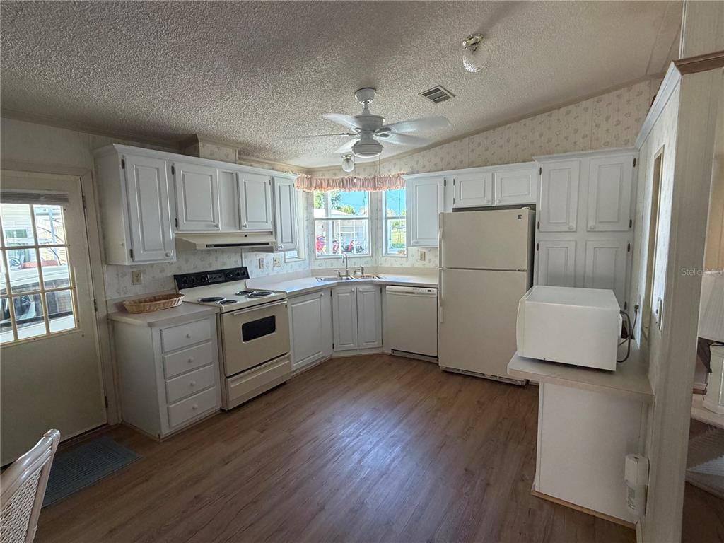 208 Eagle Punta Gorda, FL 33950 - Photo 5 of 16 a kitchen with white cabinets and white appliances