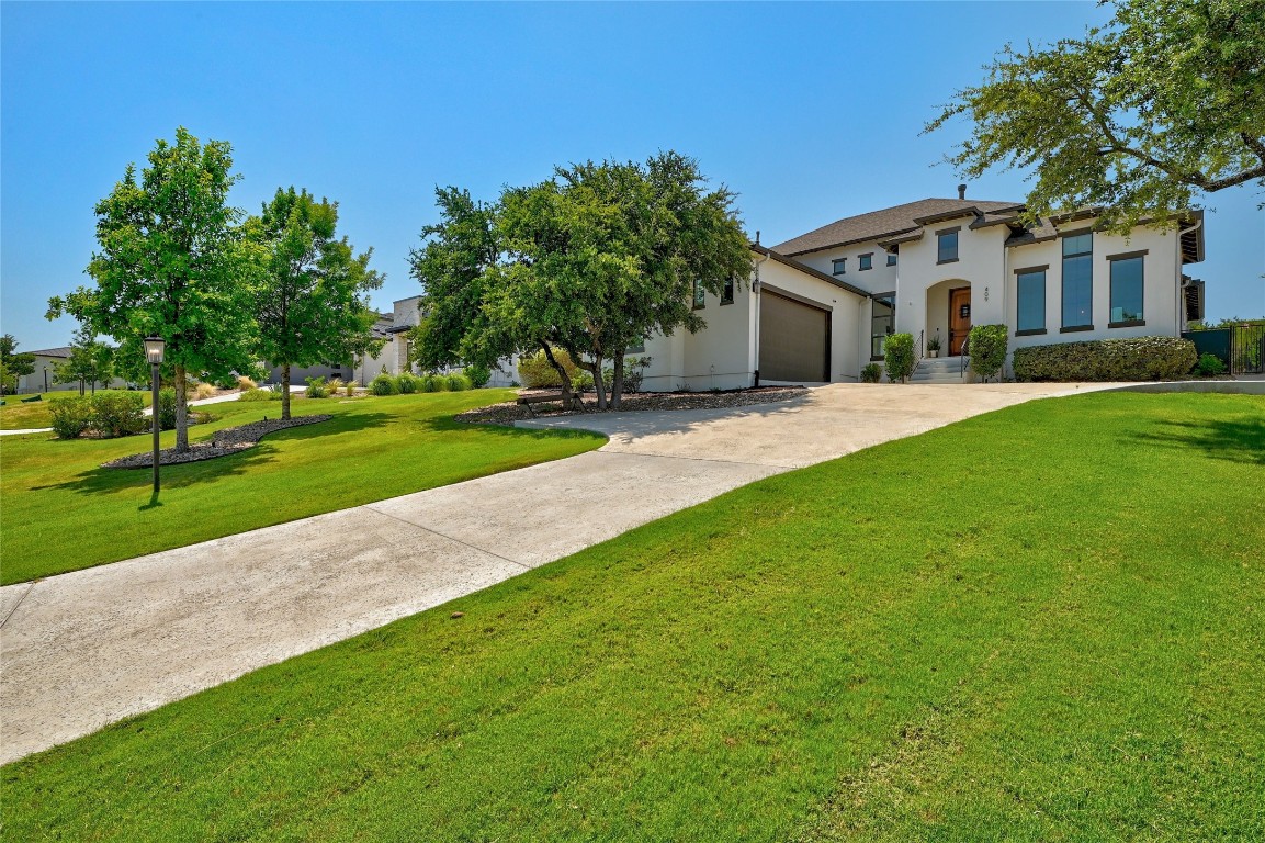 a front view of a house with a yard and trees