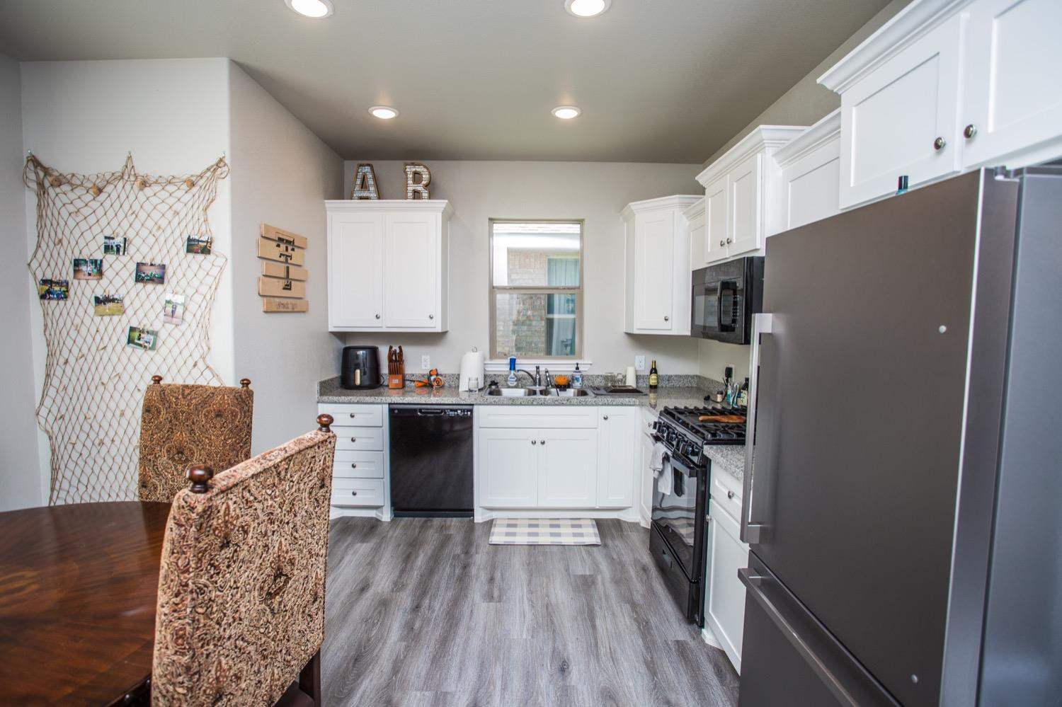 7004 10th Street Lubbock, TX 79416 - Photo 12 of 32 a kitchen with stainless steel appliances granite countertop a refrigerator stove microwave and sink