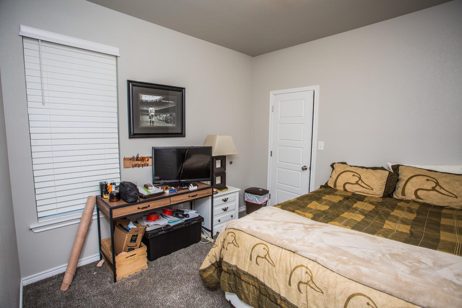 7004 10th Street Lubbock, TX 79416 - Photo 17 of 32 a bedroom with a bed and a flat screen tv