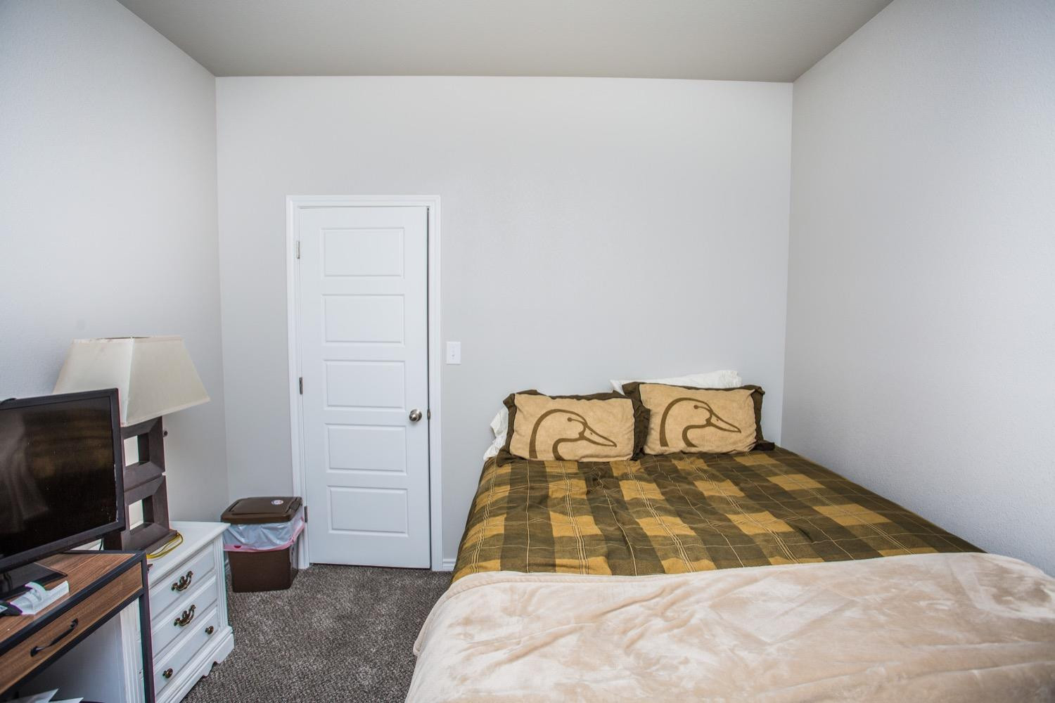7004 10th Street Lubbock, TX 79416 - Photo 18 of 32 a bedroom with a bed and flat screen tv