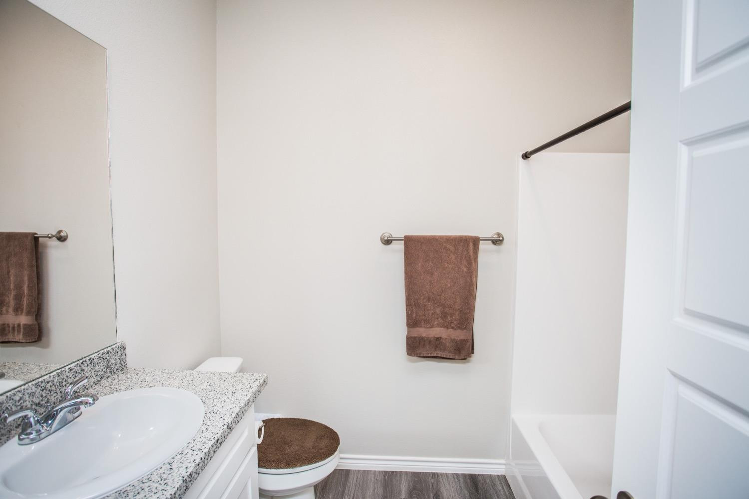 7004 10th Street Lubbock, TX 79416 - Photo 20 of 32 a white toilet sitting next to a bathroom sink