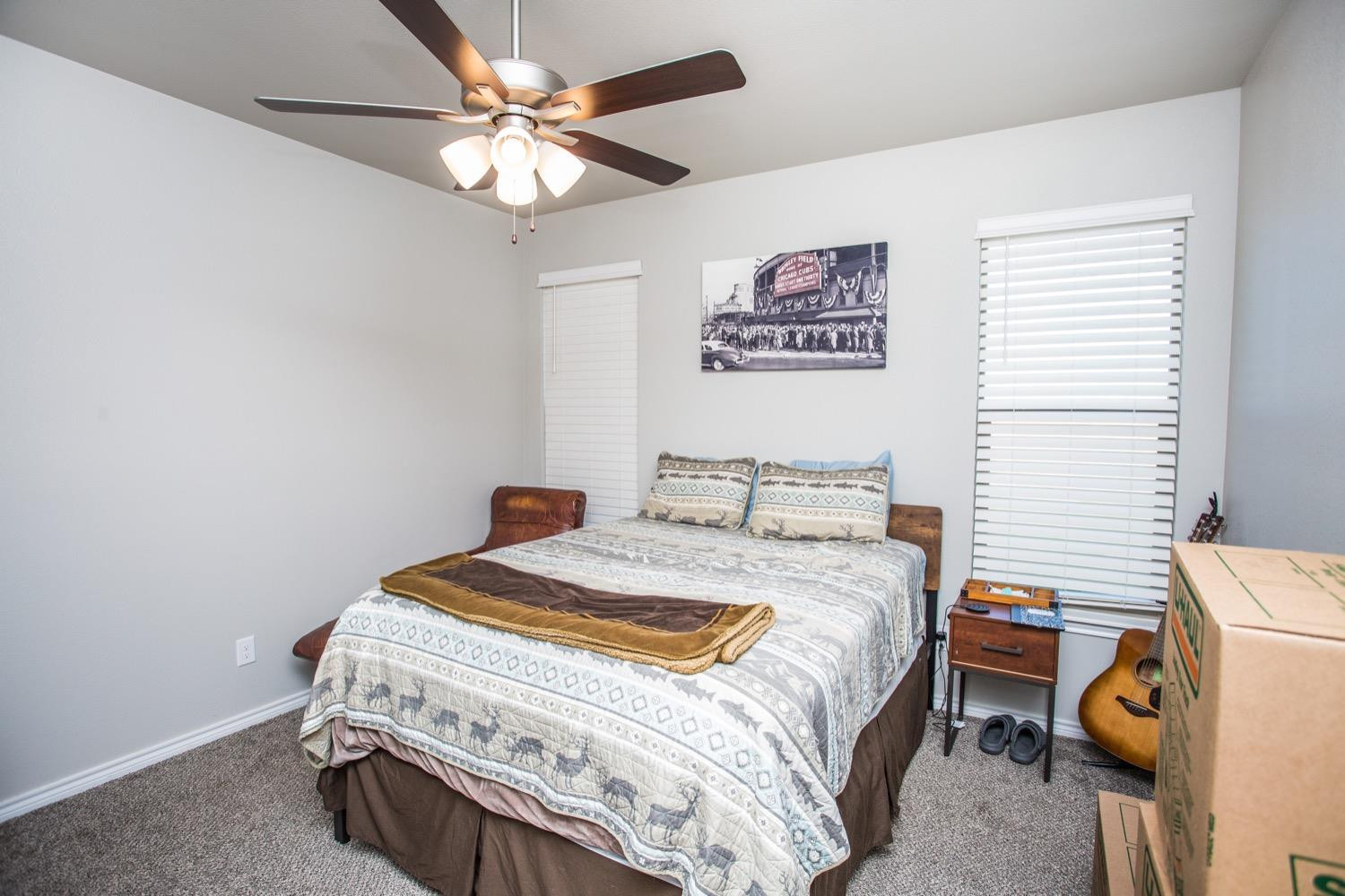 7004 10th Street Lubbock, TX 79416 - Photo 24 of 32 a bedroom with a bed and a chandelier