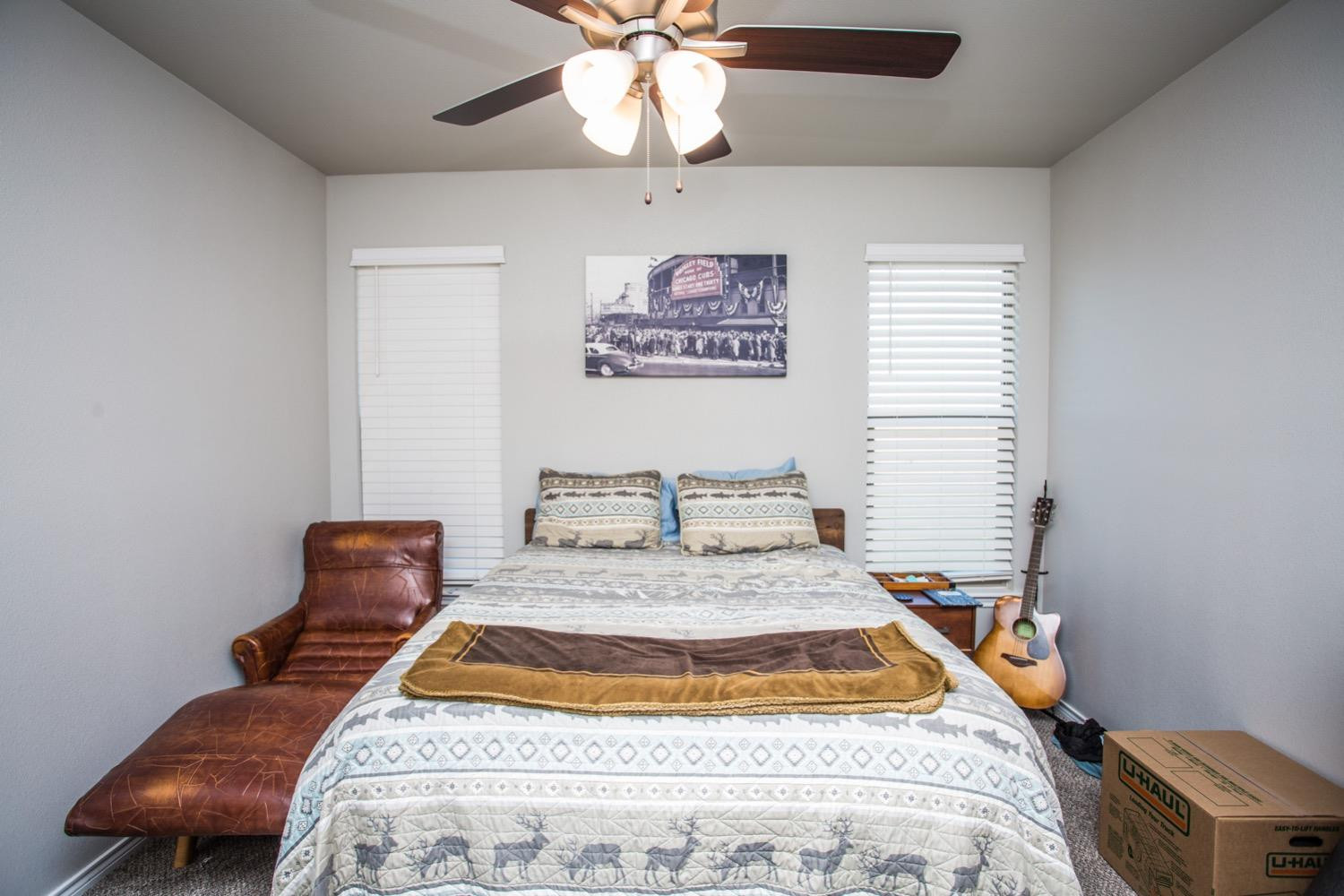 7004 10th Street Lubbock, TX 79416 - Photo 25 of 32 a bedroom with a bed and a chandelier