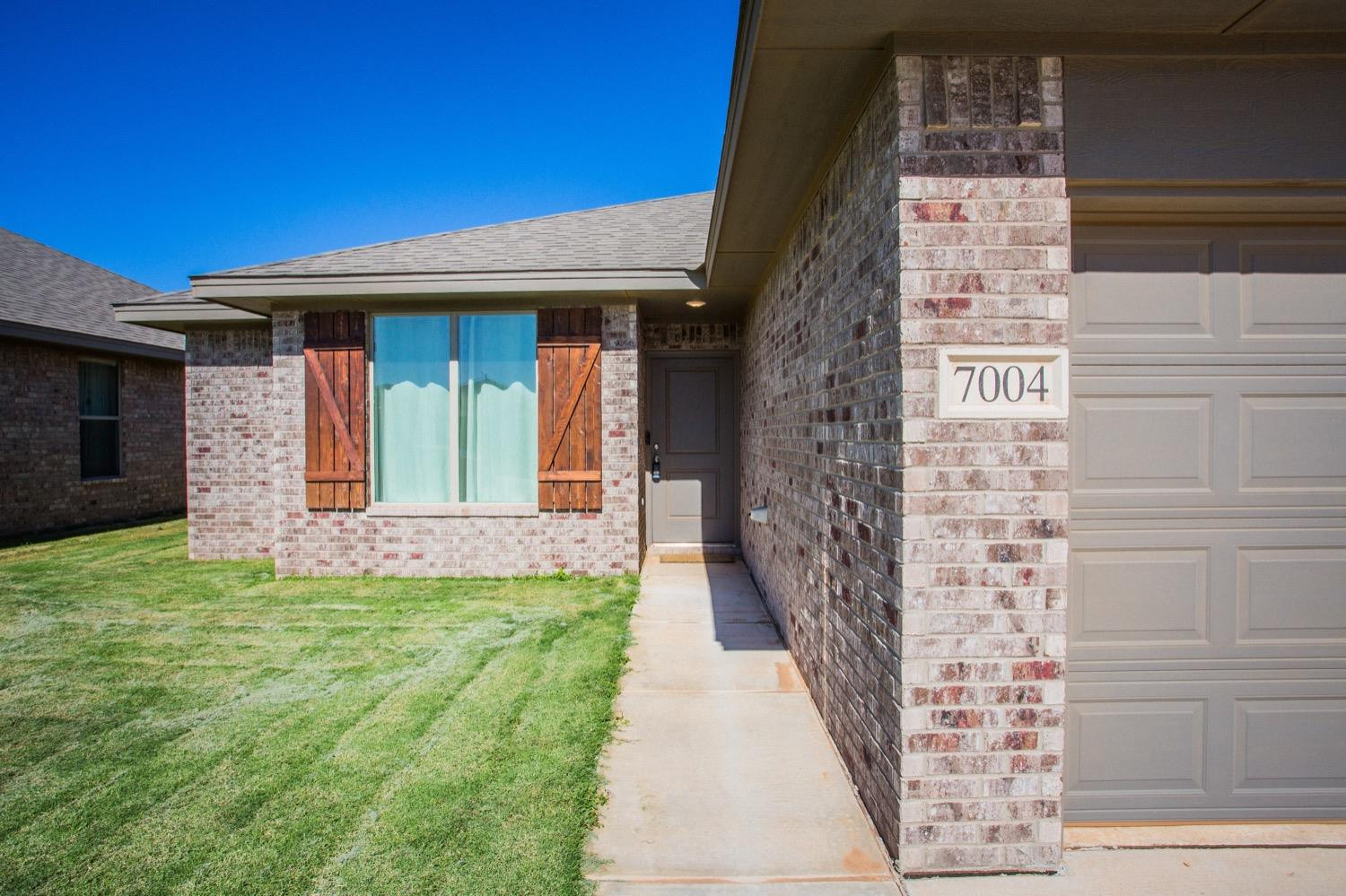 7004 10th Street Lubbock, TX 79416 - Photo 5 of 32 a front view of a house with a yard