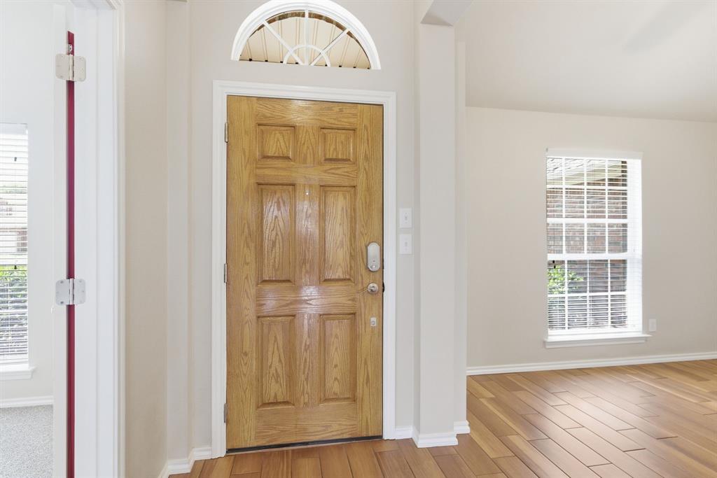817 Huebner Way Burleson, TX 76028 - Photo 6 of 35 Step through the front door with an eyebrow window to a lovely wood look porcelain tiled entry and formal dining room. Vaulted ceilings are throughout the house.