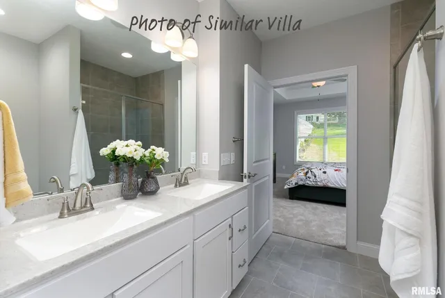 a spacious en suite bathroom with a granite countertop sink and a mirror