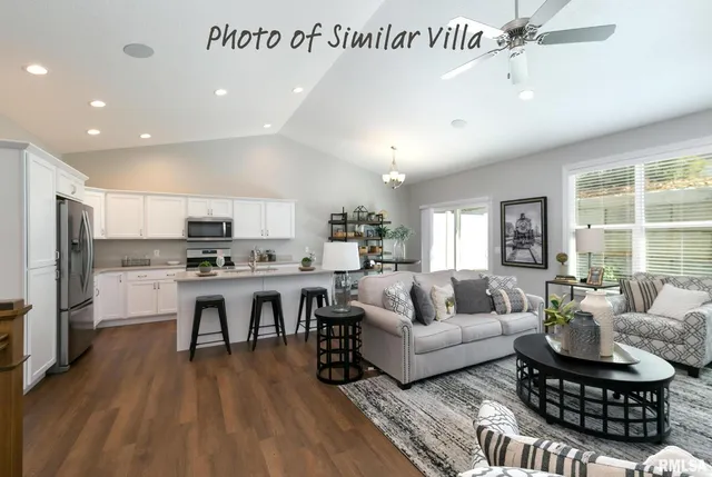 a living room with furniture kitchen view and a wooden floor