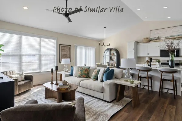 a living room with furniture kitchen view and a large window
