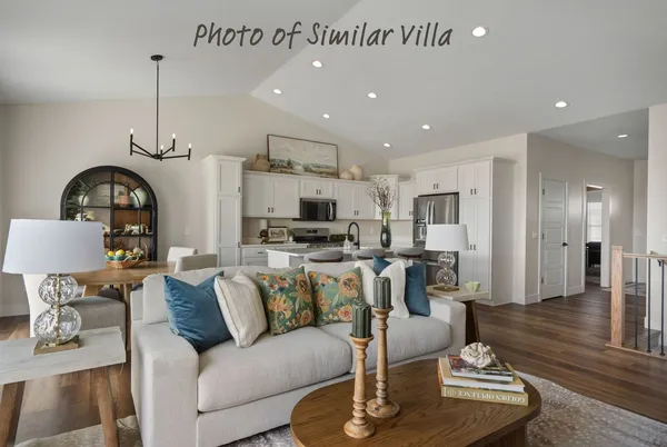 a living room with furniture kitchen view and a chandelier