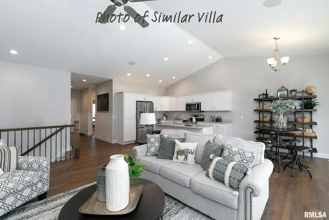 a living room with furniture kitchen view and a wooden floor