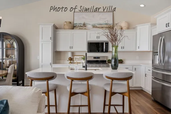 a kitchen with stainless steel appliances a table and chairs in it