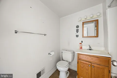 a bathroom with a toilet sink vanity and mirror