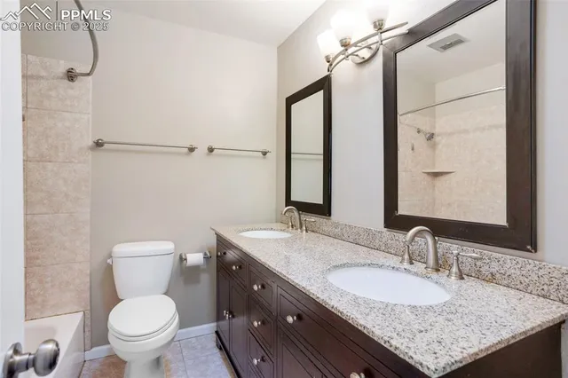 a bathroom with a granite countertop sink a toilet and a mirror