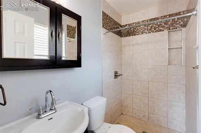 a bathroom with a sink mirror toilet and shower