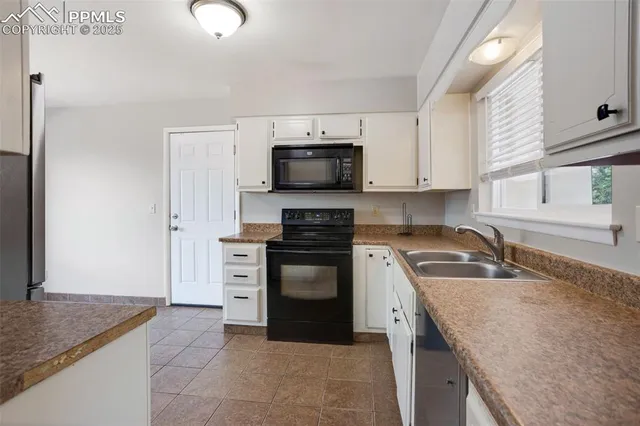 a kitchen with granite countertop a stove sink and cabinets
