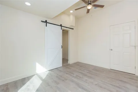 a view of a room with a ceiling fan and wooden floor