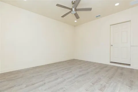an empty room with a ceiling fan and carpet