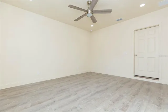 an empty room with a ceiling fan and carpet