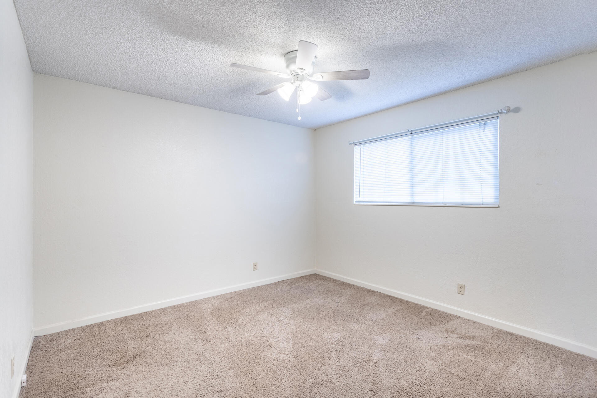 2472 Saturn Redding, CA 96002 - Photo 9 of 15 an empty room with a chandelier fan and windows