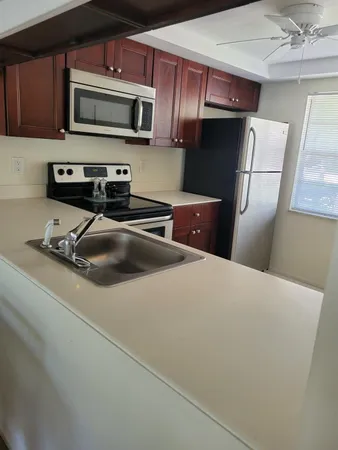 a kitchen with stainless steel appliances a refrigerator a microwave a sink and cabinets