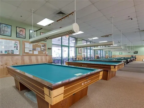 a room with pool table and windows