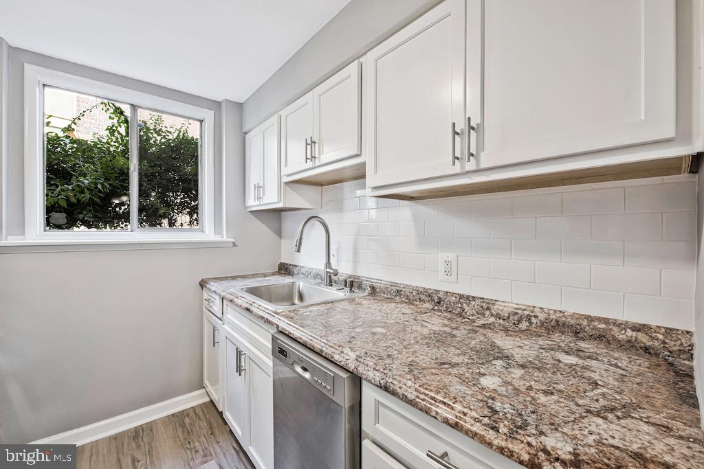 7129 Donnell Place, Unit A District Heights, MD 20747 - Photo 13 of 25 a kitchen with granite countertop white cabinets and a window