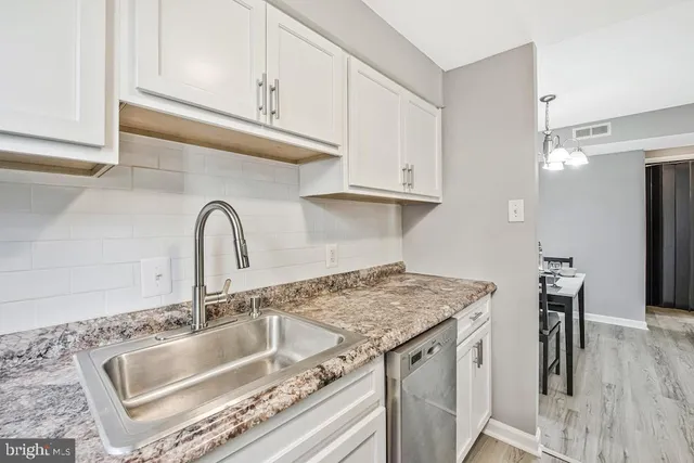 a kitchen with granite countertop a sink stainless steel appliances and cabinets