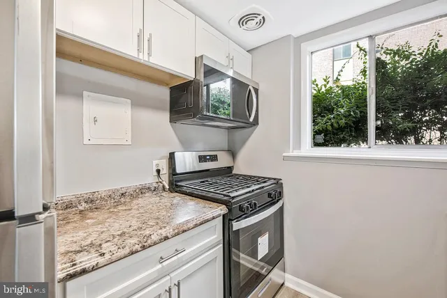 a kitchen with granite countertop a stove and a sink