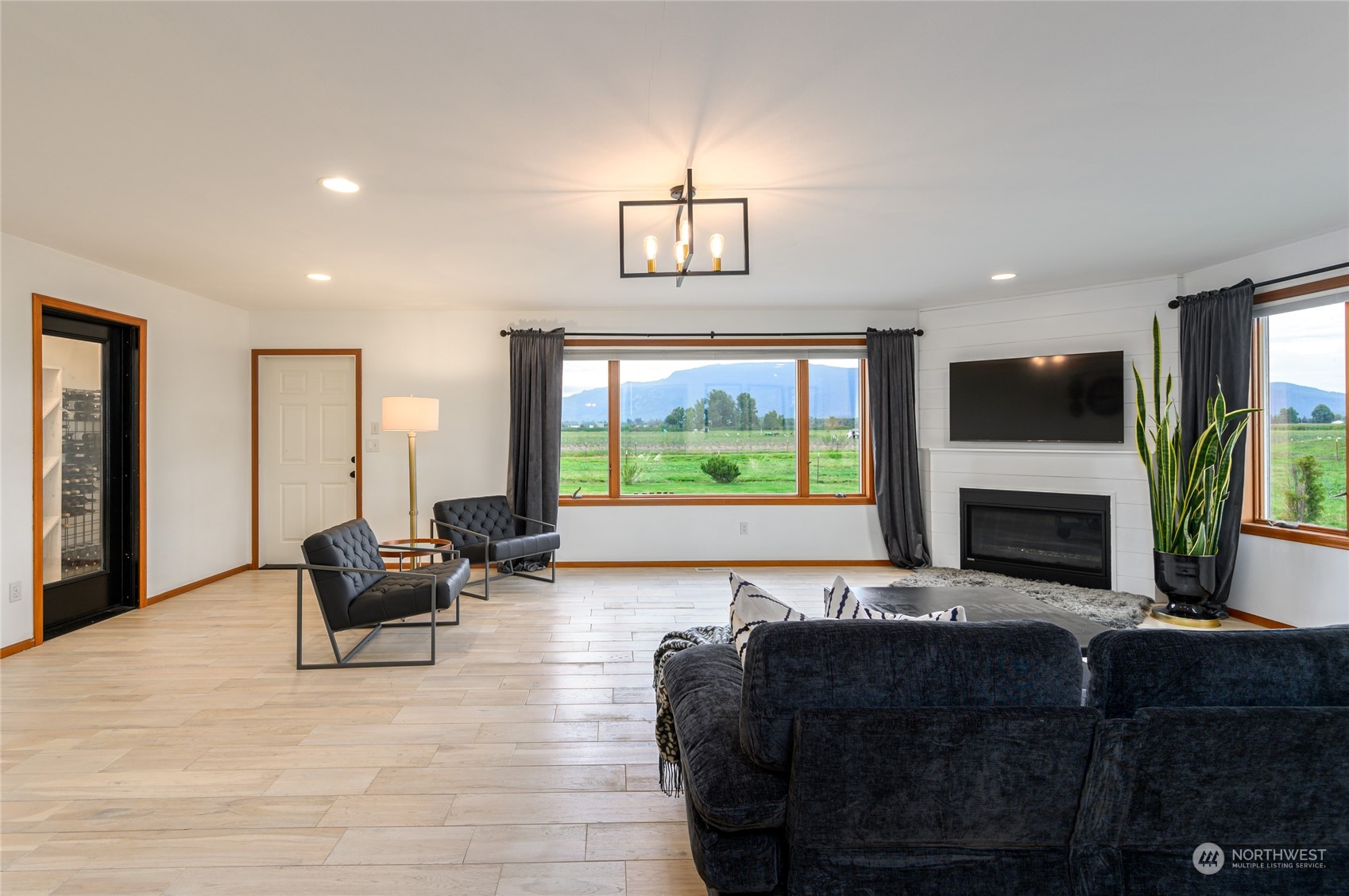 7956 Trapline Road Everson, WA 98247 - Photo 13 of 40 a living room with furniture a fireplace and a flat screen tv