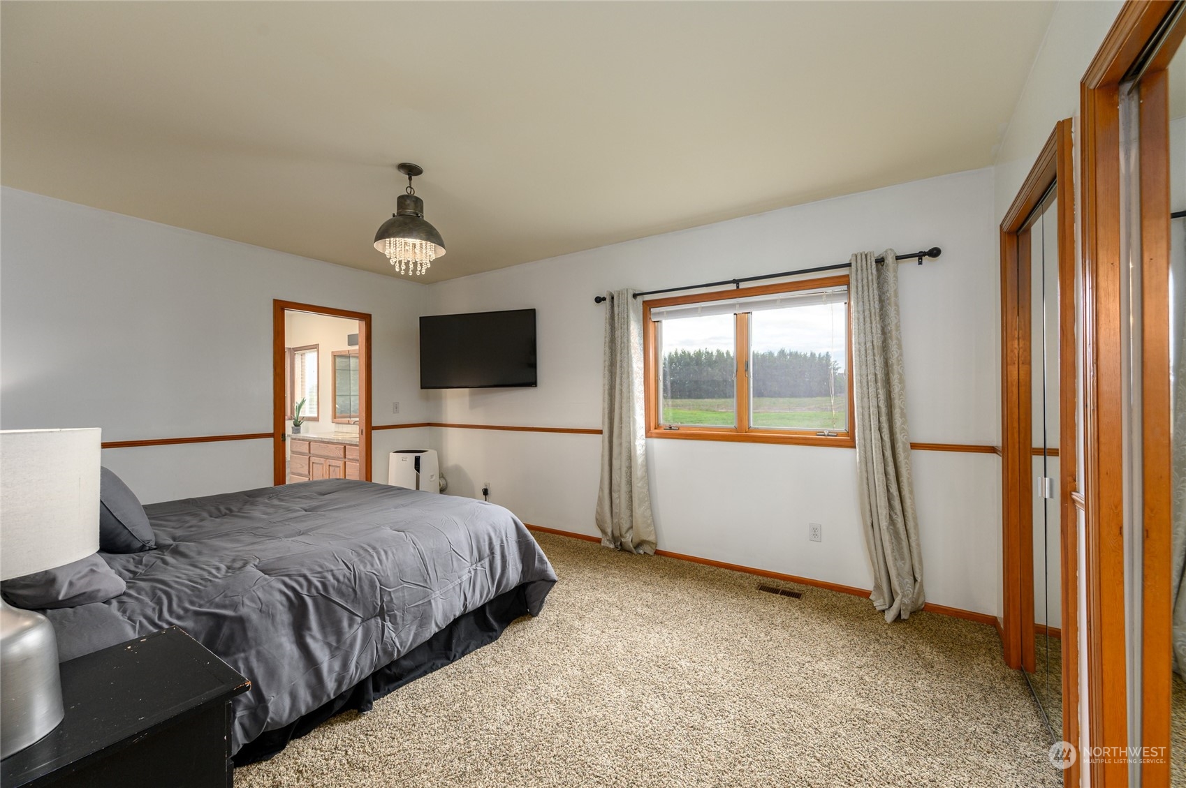 7956 Trapline Road Everson, WA 98247 - Photo 19 of 40 a spacious bedroom with a bed and a flat screen tv