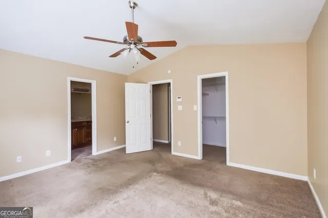 a view of a livingroom with a ceiling fan & cabinetry