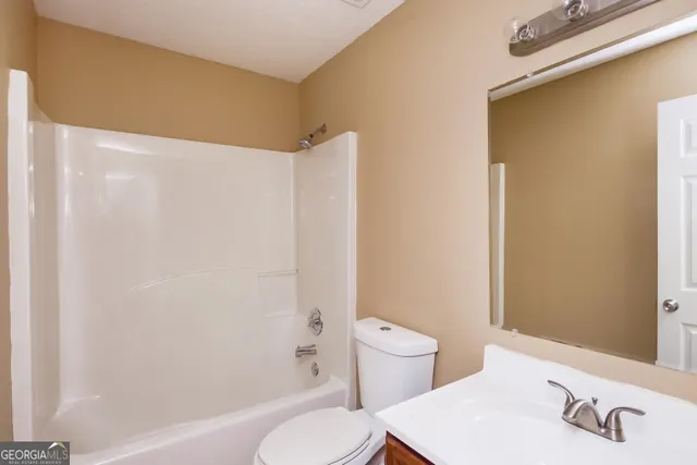 a white toilet sitting next to a bath tub