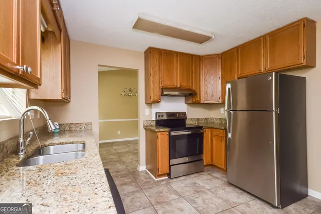 a kitchen with stainless steel appliances granite countertop a refrigerator stove and sink