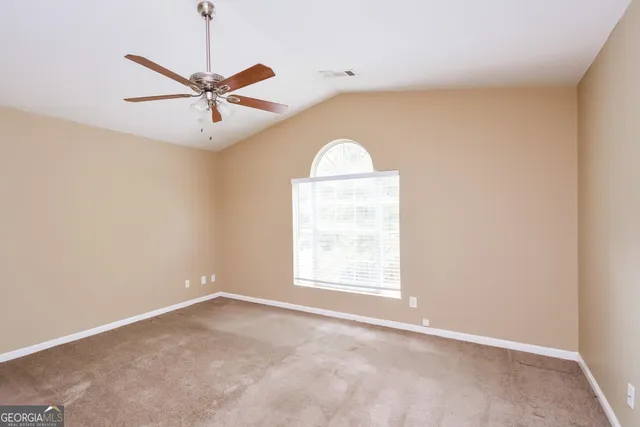 an empty room with a window and a fan