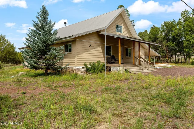 a backyard of a house with table and chairs