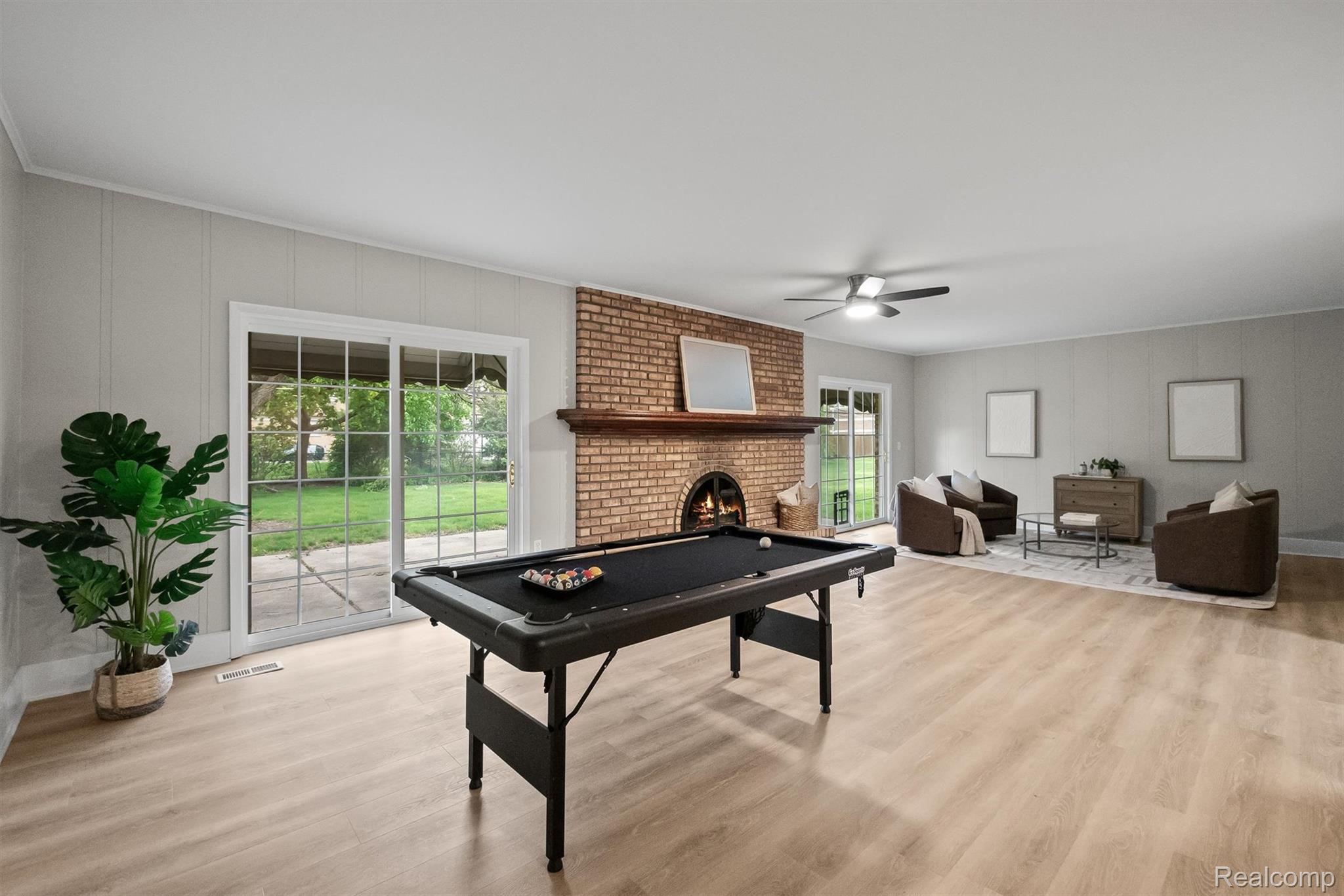 11326 Common Road Warren, MI 48093 - Photo 14 of 35 Game room featuring light wood-type flooring, ceiling fan, billiards table, a fireplace, and a decorative wall