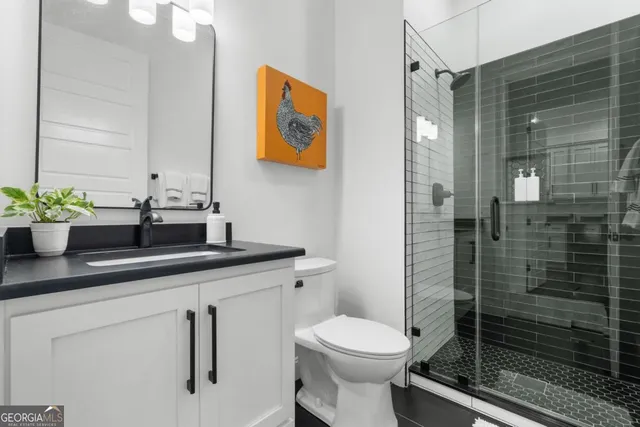 a bathroom with a sink a toilet a shower and a mirror