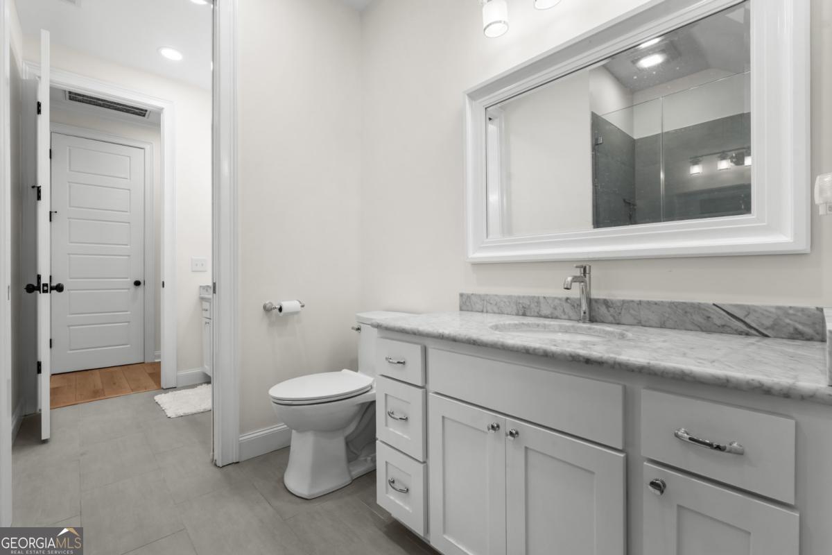 1951 Tru Fail Crossing Road Garfield, GA 30425 - Photo 22 of 49 a bathroom with a granite countertop toilet sink and mirror