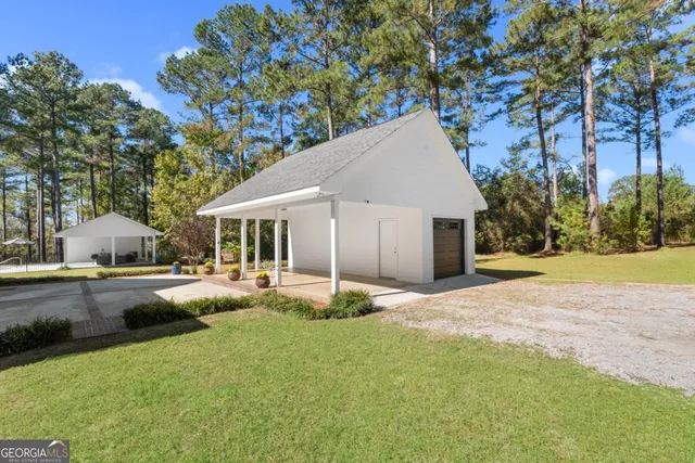 a view of a house with backyard and sitting area