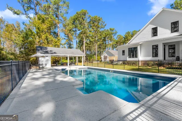 a view of a house with pool and chairs