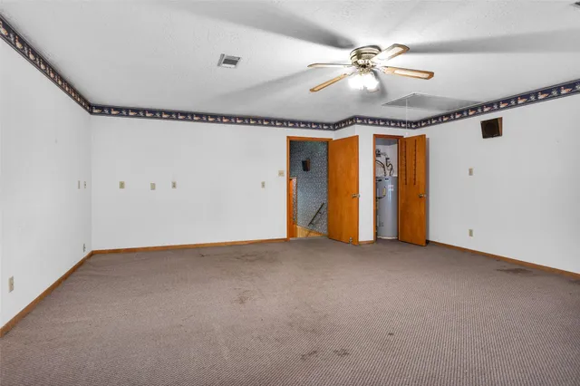 a view of an empty room with a fireplace and a window