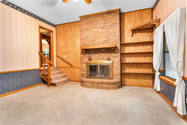 a view of an empty room with a fireplace and a window