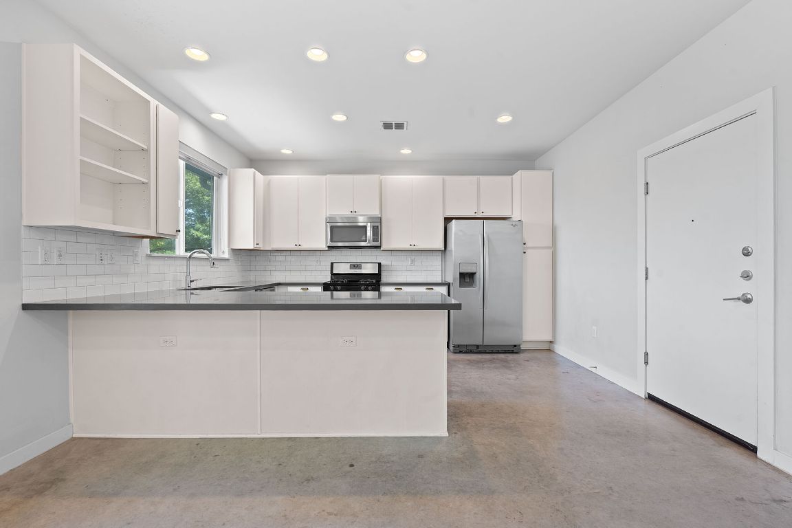 301 West Stassney Lane, Unit 7 Austin, TX 78745 - Photo 12 of 30 a kitchen with stainless steel appliances granite countertop a refrigerator sink and cabinets
