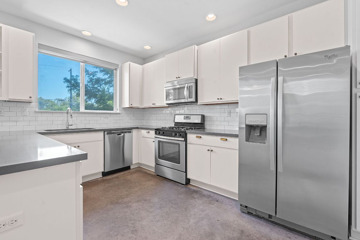 301 West Stassney Lane, Unit 7 Austin, TX 78745 - Photo 13 of 30 a kitchen with a refrigerator sink and cabinets