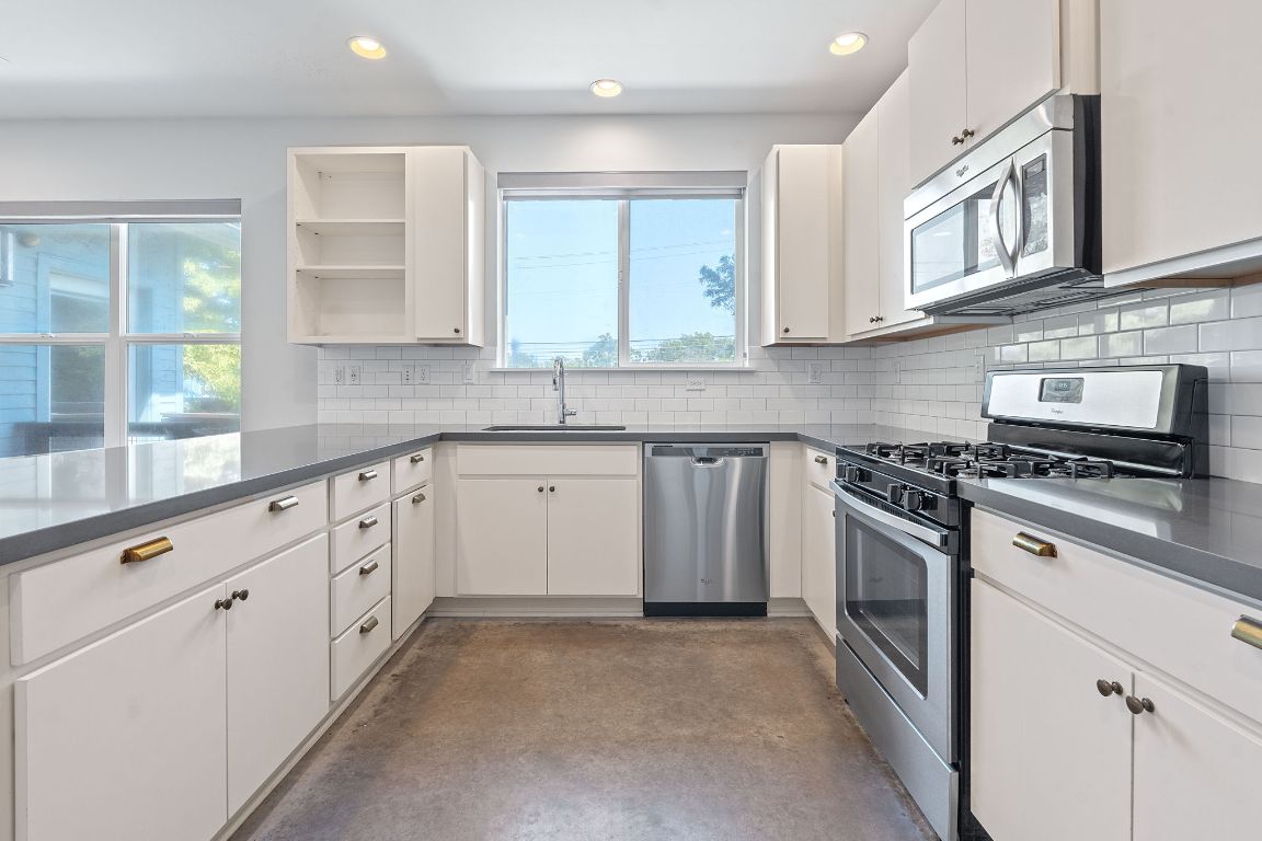 301 West Stassney Lane, Unit 7 Austin, TX 78745 - Photo 14 of 30 a kitchen with stainless steel appliances granite countertop a sink and cabinets with wooden floors