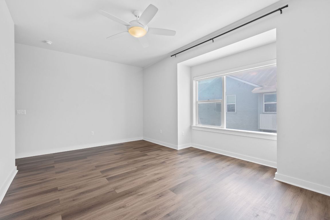 301 West Stassney Lane, Unit 7 Austin, TX 78745 - Photo 17 of 30 an empty room with wooden floor and windows